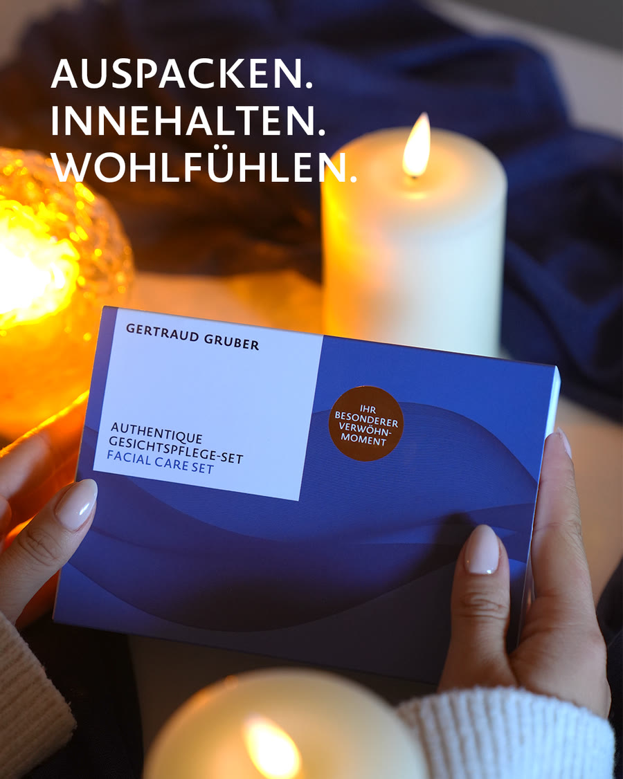 Weihnachten 2026 – Auspacken, Innehalten, Wohlfühlen Hände halten ein Gertraud Gruber Geschenkset bei Kerzenlicht